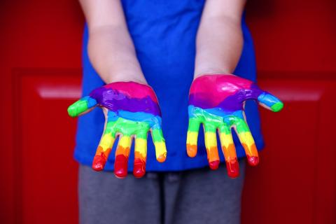 Hands with rainbow paint on them